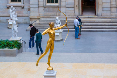 Man walking by statue in city