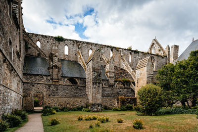 Low angle view of old building against cloudy sky