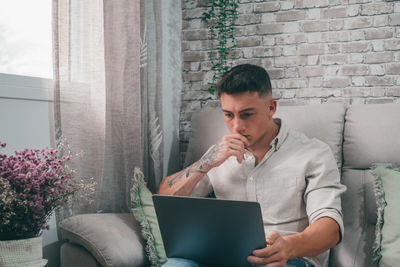 Young man using laptop at home