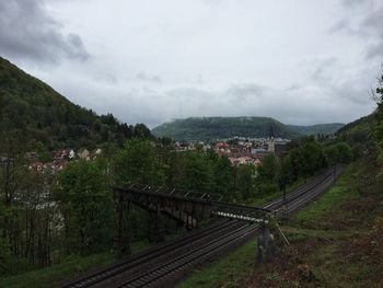 High angle view of railroad tracks by buildings against sky