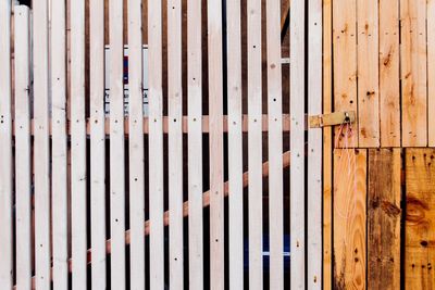 Close-up of wooden gate by fence