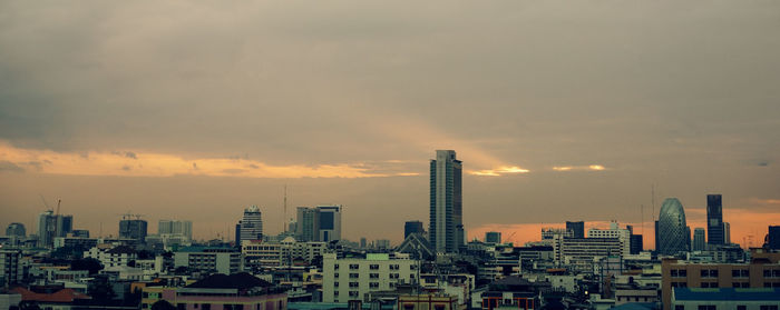 Buildings in city against sky during sunset