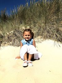 Portrait of smiling girl sitting at beach