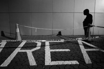 Side view of man walking against wall