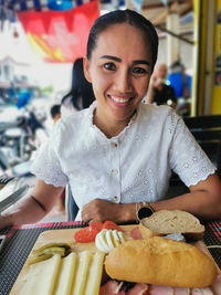 Pretty young woman in front of a rustic breakfast platter