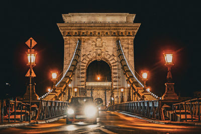 Illuminated bridge over river at night