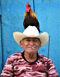 Portrait of man wearing hat against wall