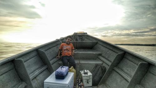 Man standing on boat in sea against sky