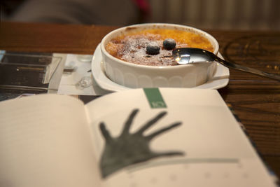 Close-up of book and creme brulee on table