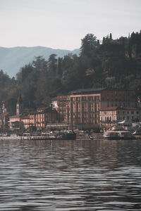 River by buildings against sky