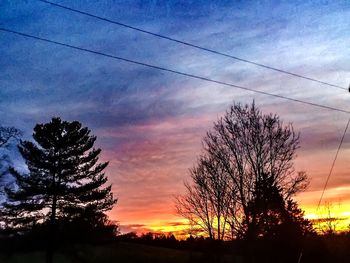 Silhouette of power lines against cloudy sky