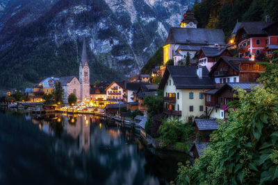 River amidst illuminated buildings in city at dusk