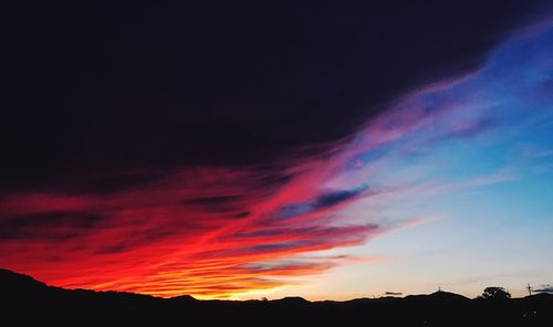 Scenic view of dramatic sky over silhouette landscape