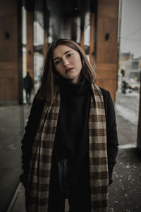 Portrait of young woman standing in corridor