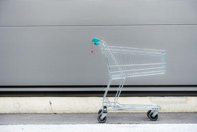 Close-up of shopping cart against wall