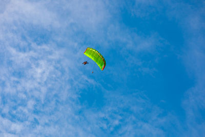 Low angle view of person paragliding against sky