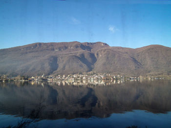 Scenic view of lake and mountains against blue sky