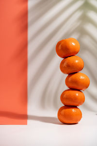 Stacked tangerines isolated on white and orange background. healthy eating. minimalism 