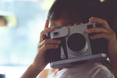 Close-up of girl photographing with camera in car