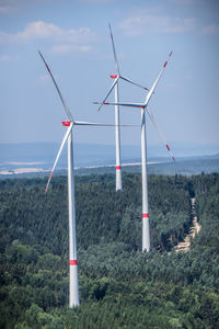 Windmills on landscape against sky