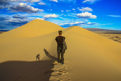 Full length of man walking on sand dune