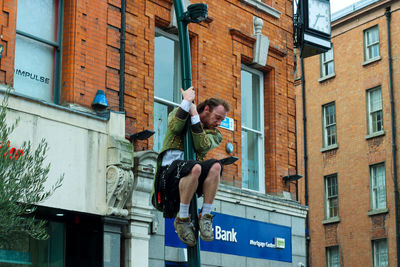 Low angle view of man on building in city