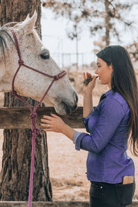 Young woman with horse at ranch
