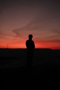 Silhouette man standing against sky during sunset
