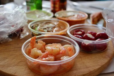 High angle view of various food in containers on wooden table