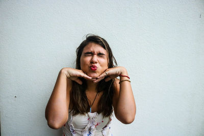 Portrait of young woman against white background