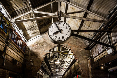 Low angle view of clock hanging on ceiling at railroad station