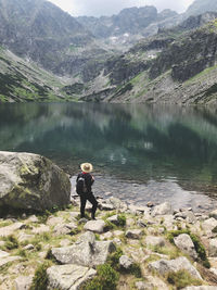 Man looking at lake against mountain