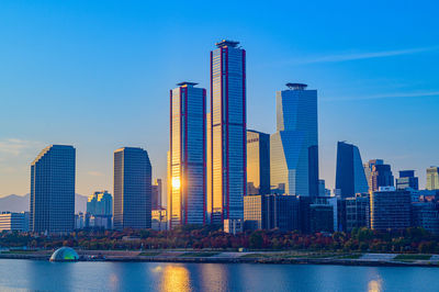 Modern buildings in city against blue sky