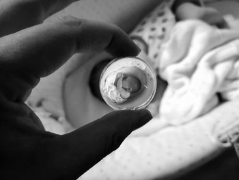 Close-up of person holding glass ball over baby