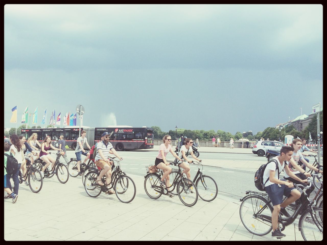 transfer print, bicycle, transportation, land vehicle, auto post production filter, mode of transport, parked, stationary, parking, sky, street, built structure, architecture, men, building exterior, motorcycle, outdoors, city, railing, day