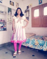 Portrait of smiling young woman standing at home