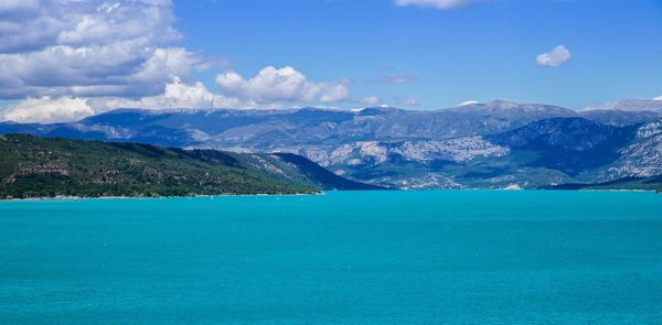 Scenic view of calm blue sea against mountain range