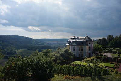 Panoramic view of palace in green valley against sky