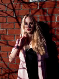 Portrait of beautiful woman standing against wall