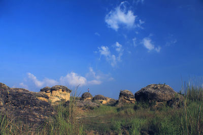 Rock formations on landscape against blue sky