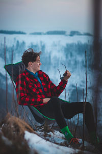 Candid portrait of a smiling teenager aged 15-20 of european descent sitting on a chair 