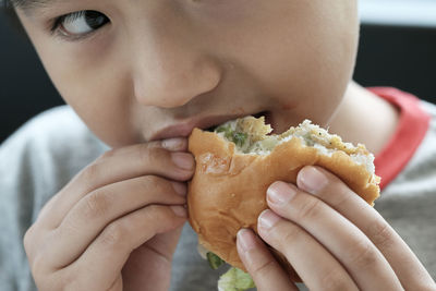 Close-up of boy eating burger