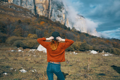 Rear view of man photographing against mountain range