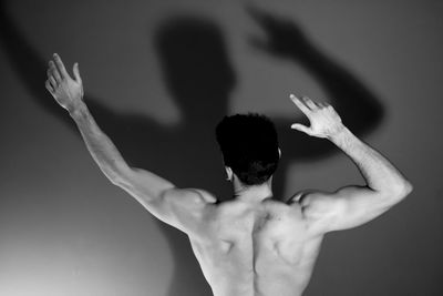 Rear view of man with arms raised