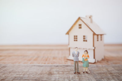 Close-up of figurines and model house on table