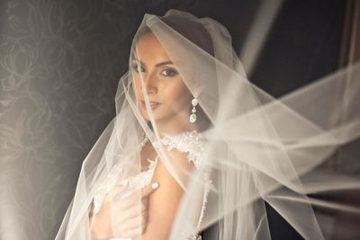 Portrait of beautiful bride against wallpaper