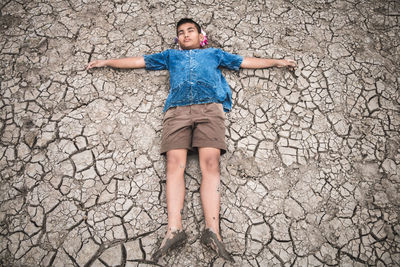 Portrait of teenage boy standing against stone wall