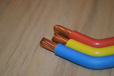 Close-up of colorful cables on wooden table