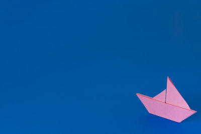 Low angle view of paper flag against clear blue sky