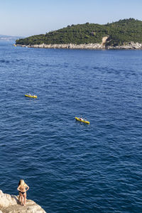 High angle view of people on sea against mountain